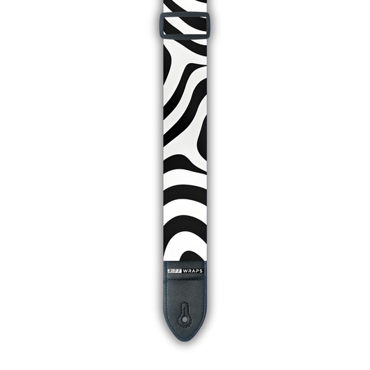 A black and white zebra patterned padded guitar strap with leather ends.