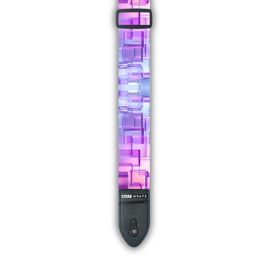 A padded guitar strap with a geometric 3D cube pattern in shades of pink and purple.