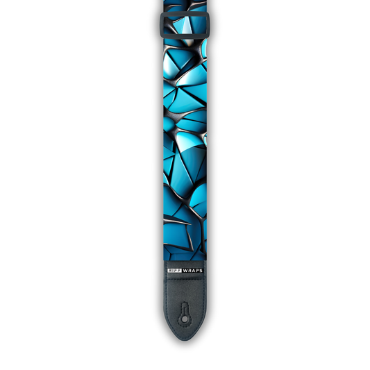 A padded guitar strap with a geometric voronoi pattern in blue and black colors, showing the brand logo 'Riff Wraps' at the end.