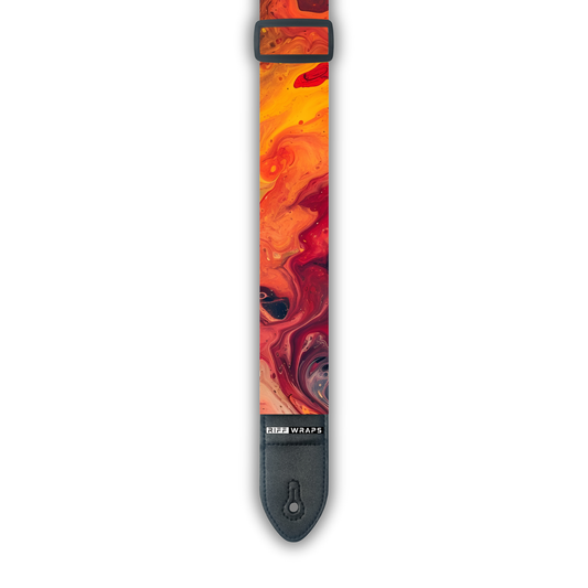 An orange and red padded guitar strap with a swirling pattern, showing the buckle and part of the strap.