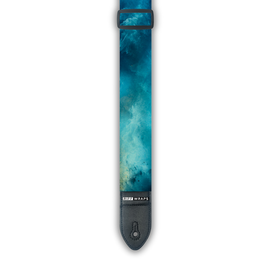 A padded guitar strap with a blue watercolor design.