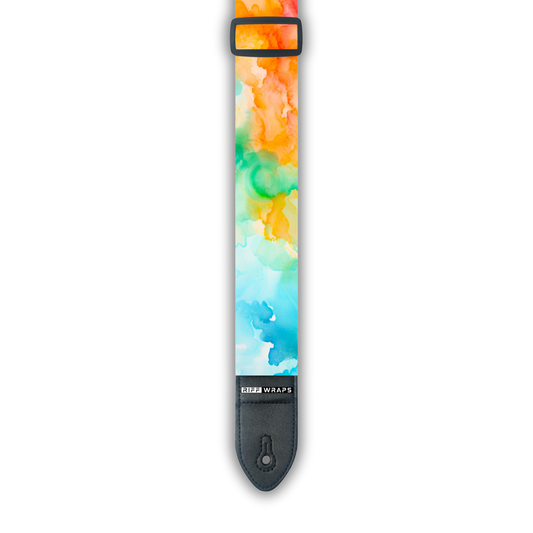 A padded guitar strap with a watercolour design featuring shades of blue, green, orange, and red.